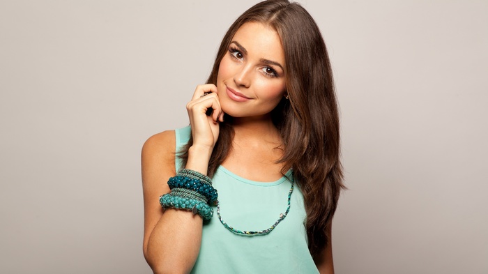 Olivia Culpo wearing a teal top and bracelets