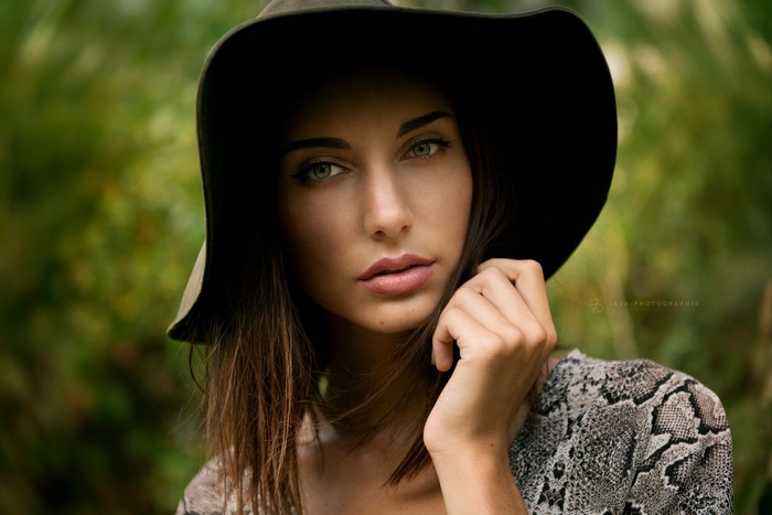 Woman wearing a hat and snake print shirt