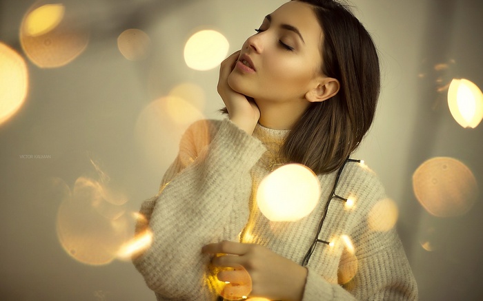 Woman with closed eyes and string lights