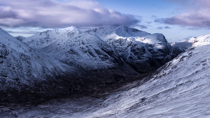 Snow-covered mountains under a cloudy sky