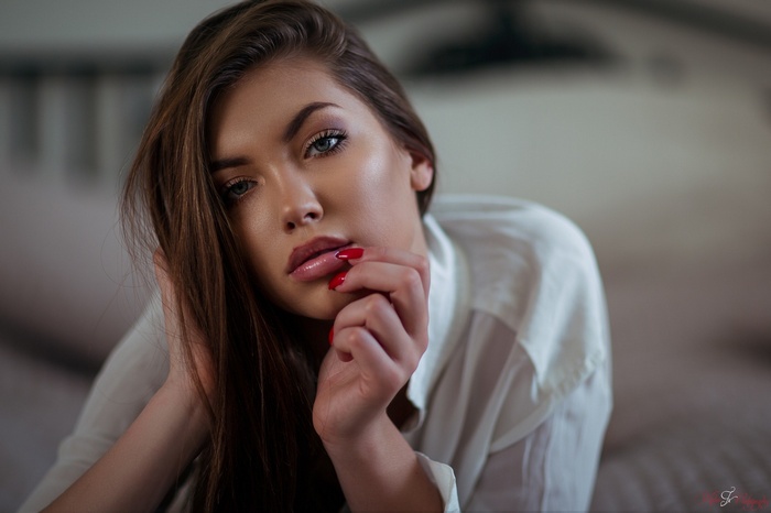 Woman with red nails in a white shirt