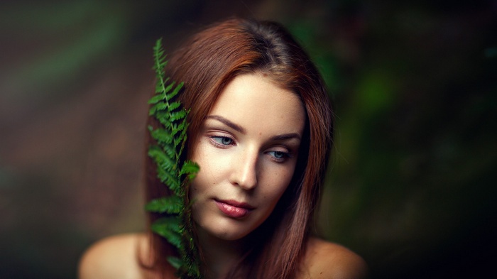 Woman with fern in forest portrait