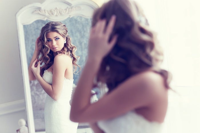 Bride in a wedding dress looking in a mirror
