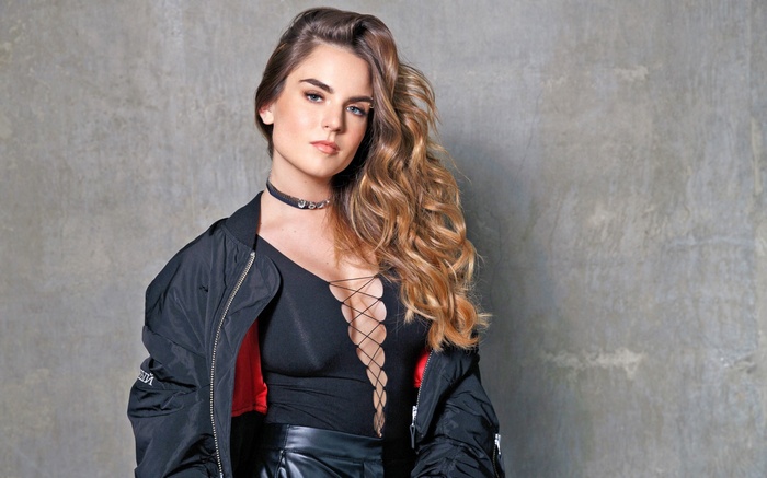 JoJo with long brown hair wearing a black jacket