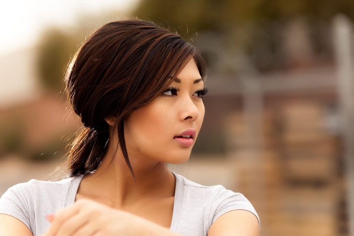 Asian woman with dark hair wearing a grey shirt