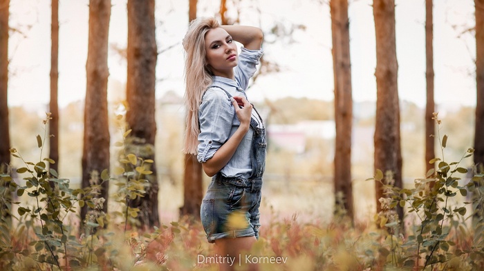 Woman in denim overalls and shirt in forest