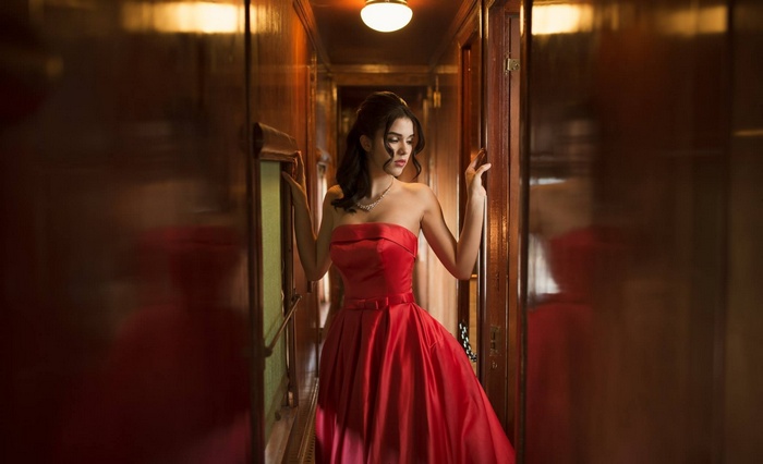 Woman in red strapless dress on a train