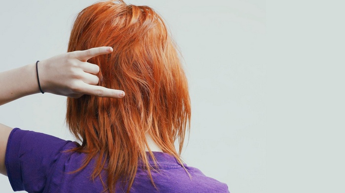 Woman with red hair making rock on gesture