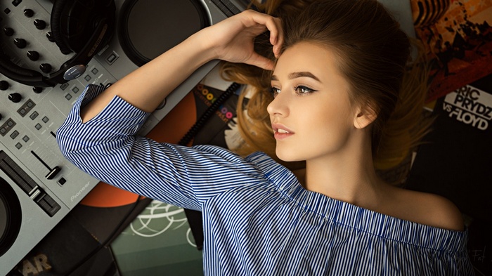 Woman lying on DJ equipment and records
