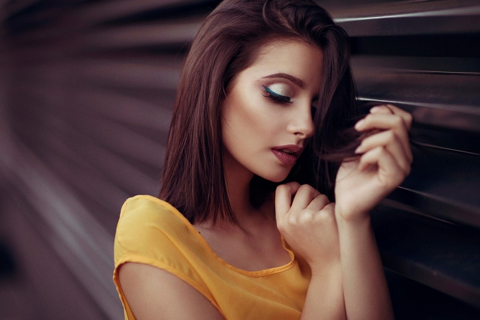 Woman with blue eyeliner and yellow shirt