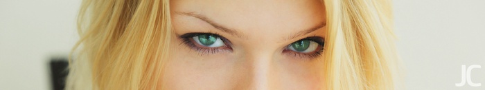 Close-up of a woman's green eyes and blonde hair