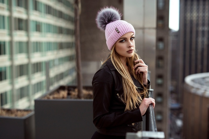 Woman wearing a pink beanie on a balcony