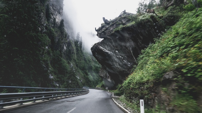 Winding mountain road through a foggy gorge