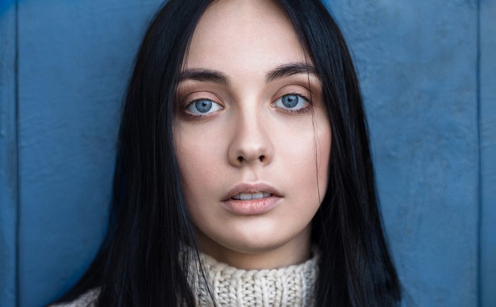 Portrait of a woman with black hair and blue eyes