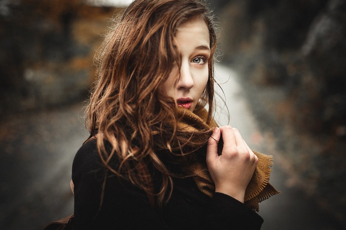 Woman with brown hair wearing a scarf outdoors