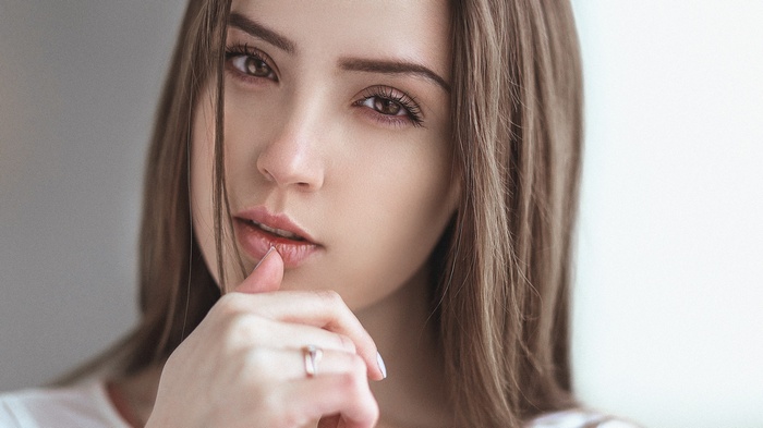 Woman with finger on lips looking at viewer