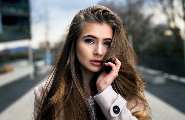Woman with long brown hair wearing a white coat