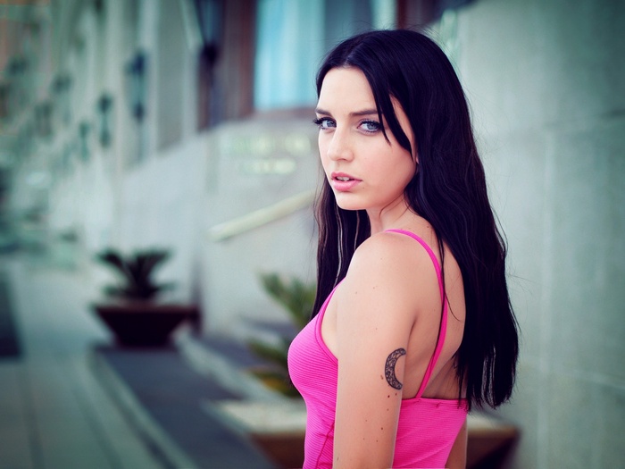 Woman with dark hair and a moon tattoo