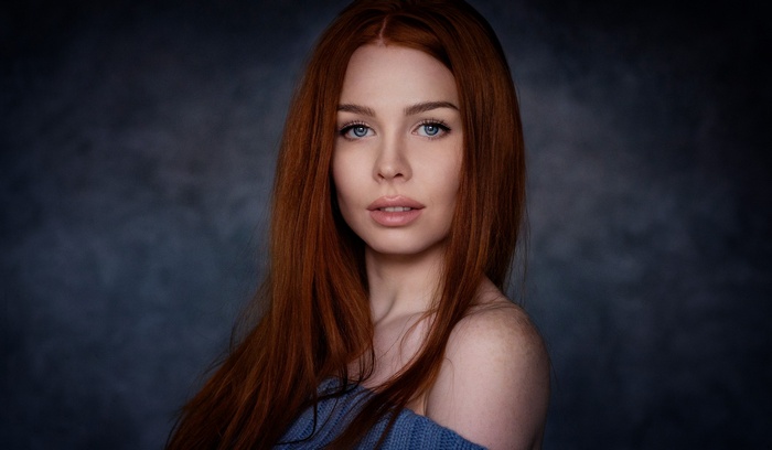 Redhead woman with blue eyes in a blue sweater