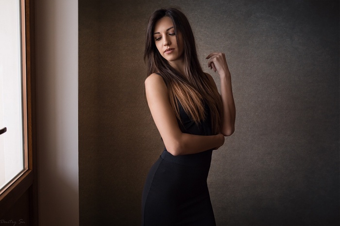 Woman in black dress by the window