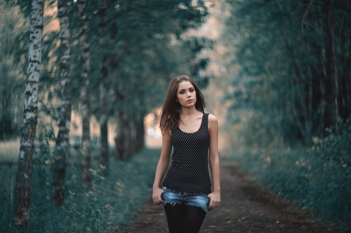 Woman in polka dot tank top and jean shorts in a forest
