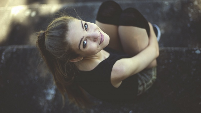 Woman with ponytail sitting on steps