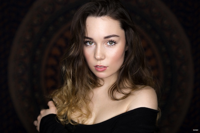 Woman with dark hair and off-the-shoulder top