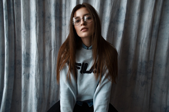 Woman wearing Fila sweatshirt and glasses