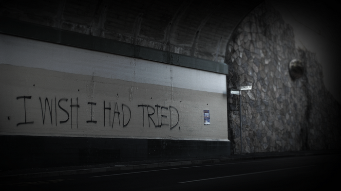 Graffiti quote "I wish I had tried" on a wall