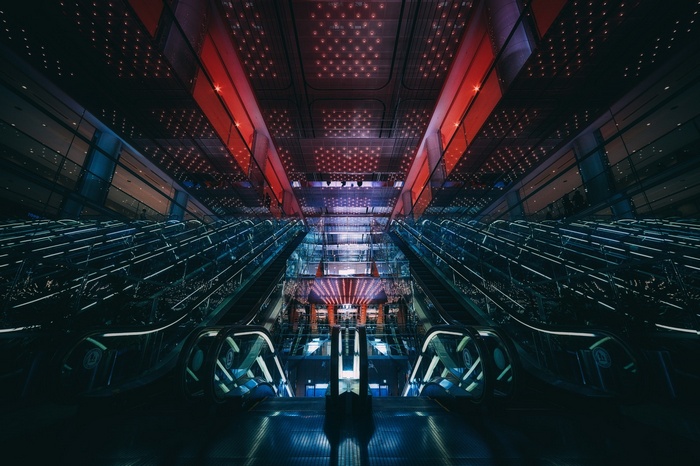 Modern escalator hall with red and blue lights