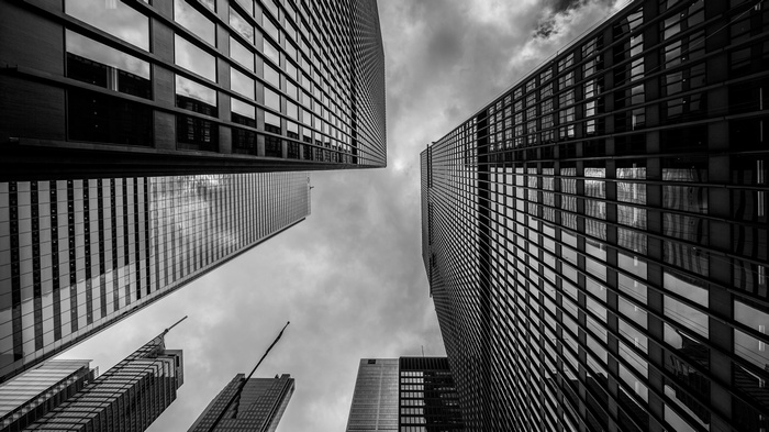 Low angle view of modern skyscrapers against cloudy sky