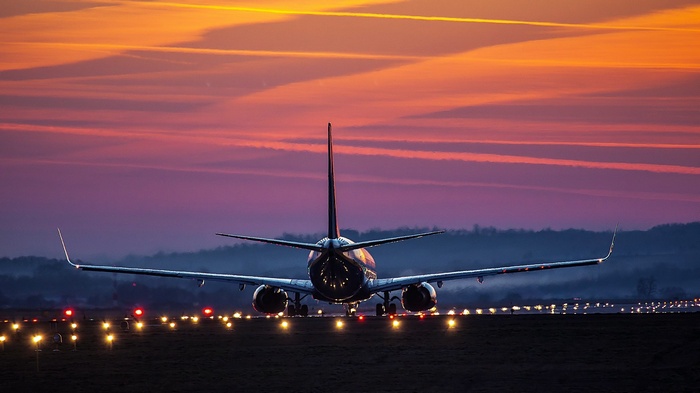 Airplane on runway at sunset