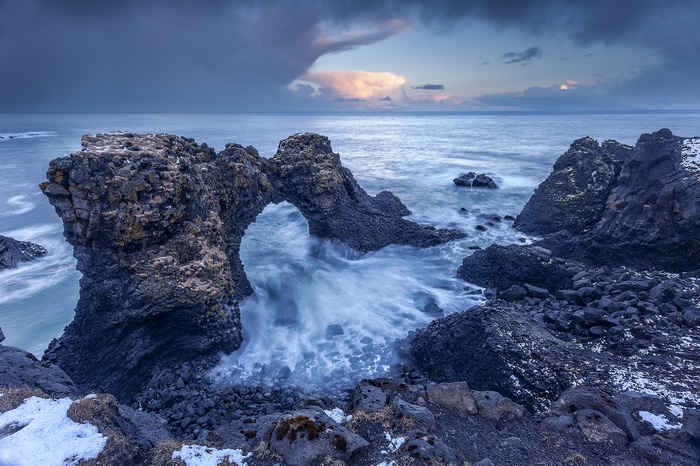 Sea arch with waves crashing on rocks