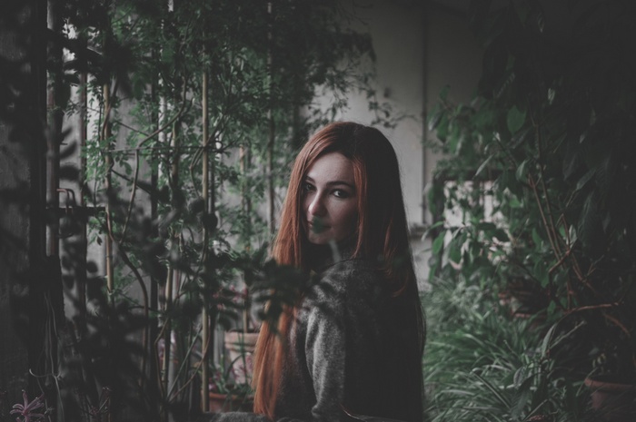 Redhead woman looking over shoulder in garden