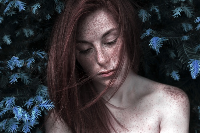 Redhead woman with freckles in nature