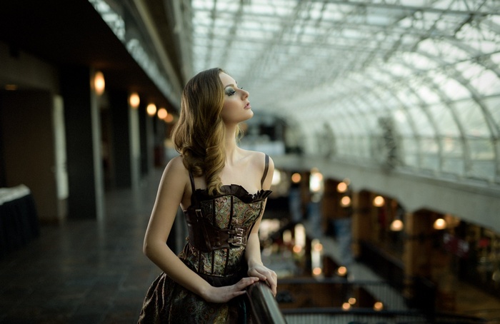 Woman in corset dress posing indoors