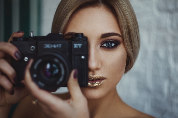 Woman holding a camera, close-up portrait