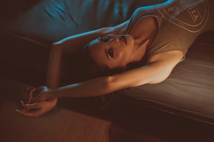 Woman lying on bed looking at viewer
