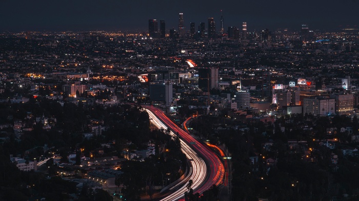 Los Angeles cityscape at night with light trails on highway