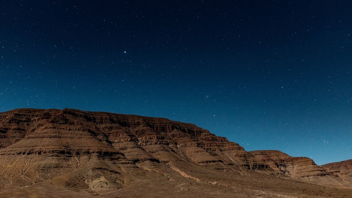 Rocky mountains under a starry night sky