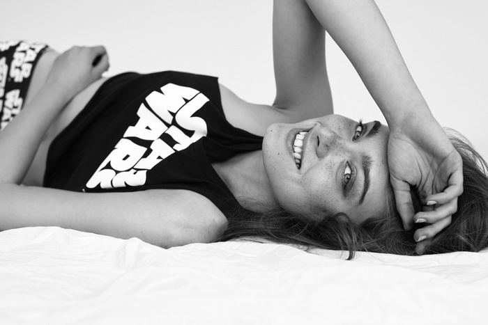 Woman in Star Wars top lying on bed