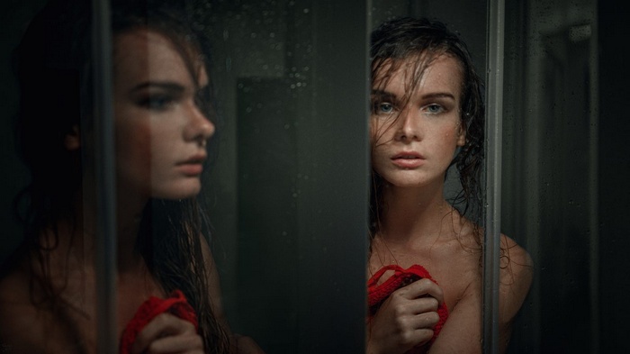 Woman with wet hair in a shower, reflection