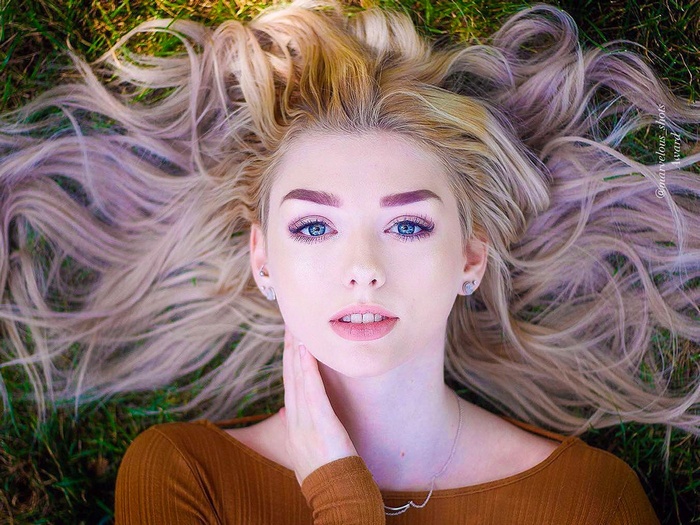 Woman with blonde hair lying on grass