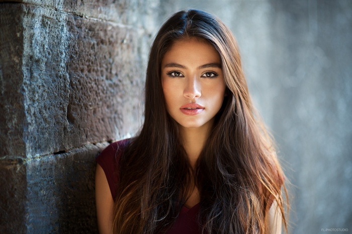 Woman leaning against a stone wall