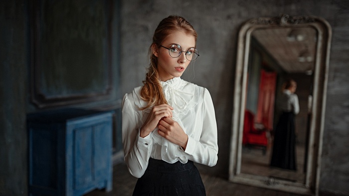 Woman with glasses in a white blouse and black skirt