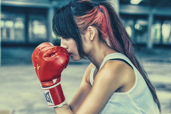 Woman with dyed hair wearing boxing gloves