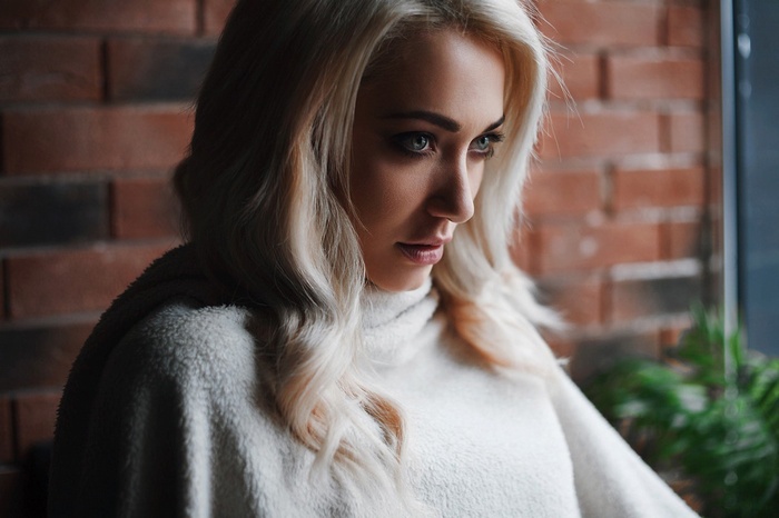 Woman with blonde hair wearing a white sweater