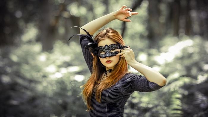 Woman wearing a black masquerade mask outdoors