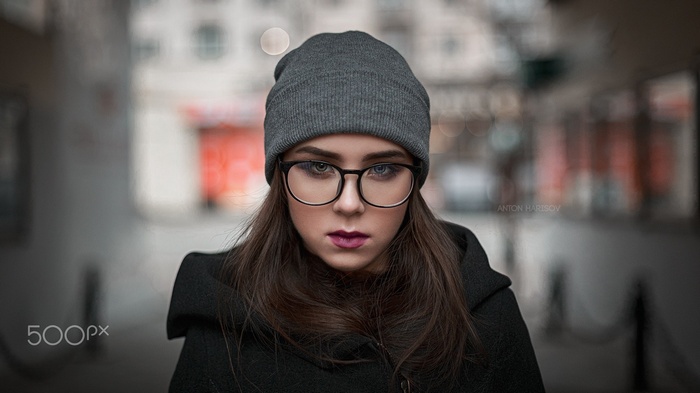 Woman wearing glasses and beanie in urban setting
