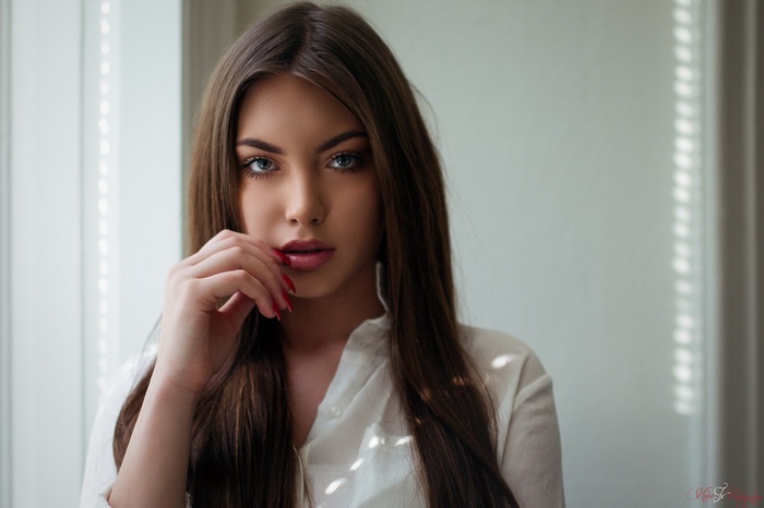 Woman with long brown hair and red nails